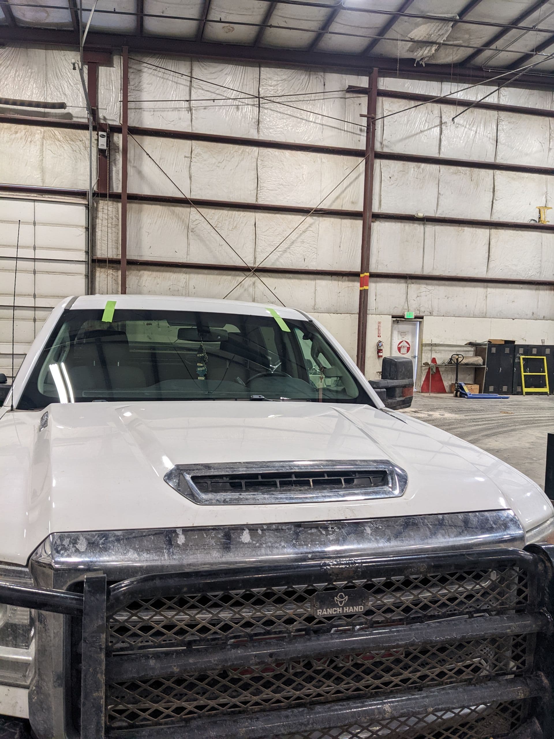Heavy duty work truck with a new windshield taped while the urethane cures