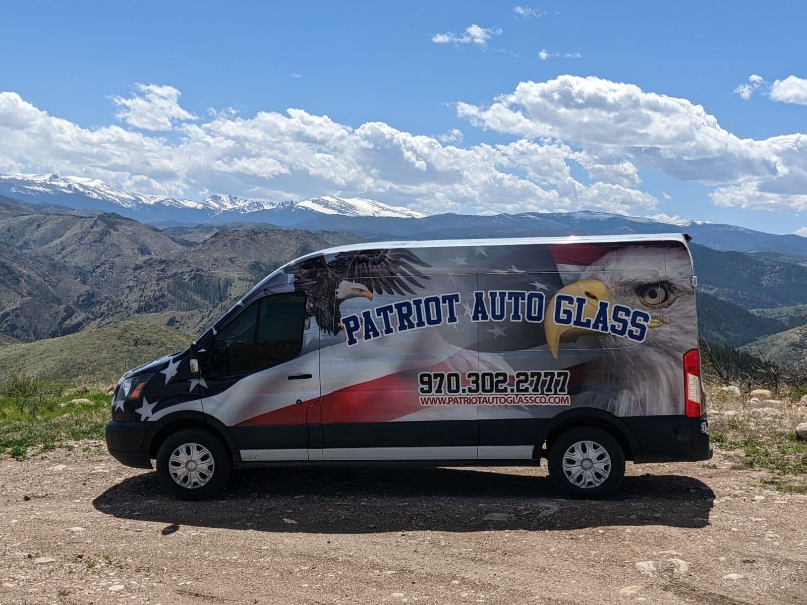 The Patriot Auto Glass service van parked above the Colorado Rockies